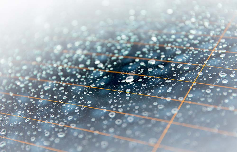 Technician inspecting solar panels during rainy weather in Mauritius